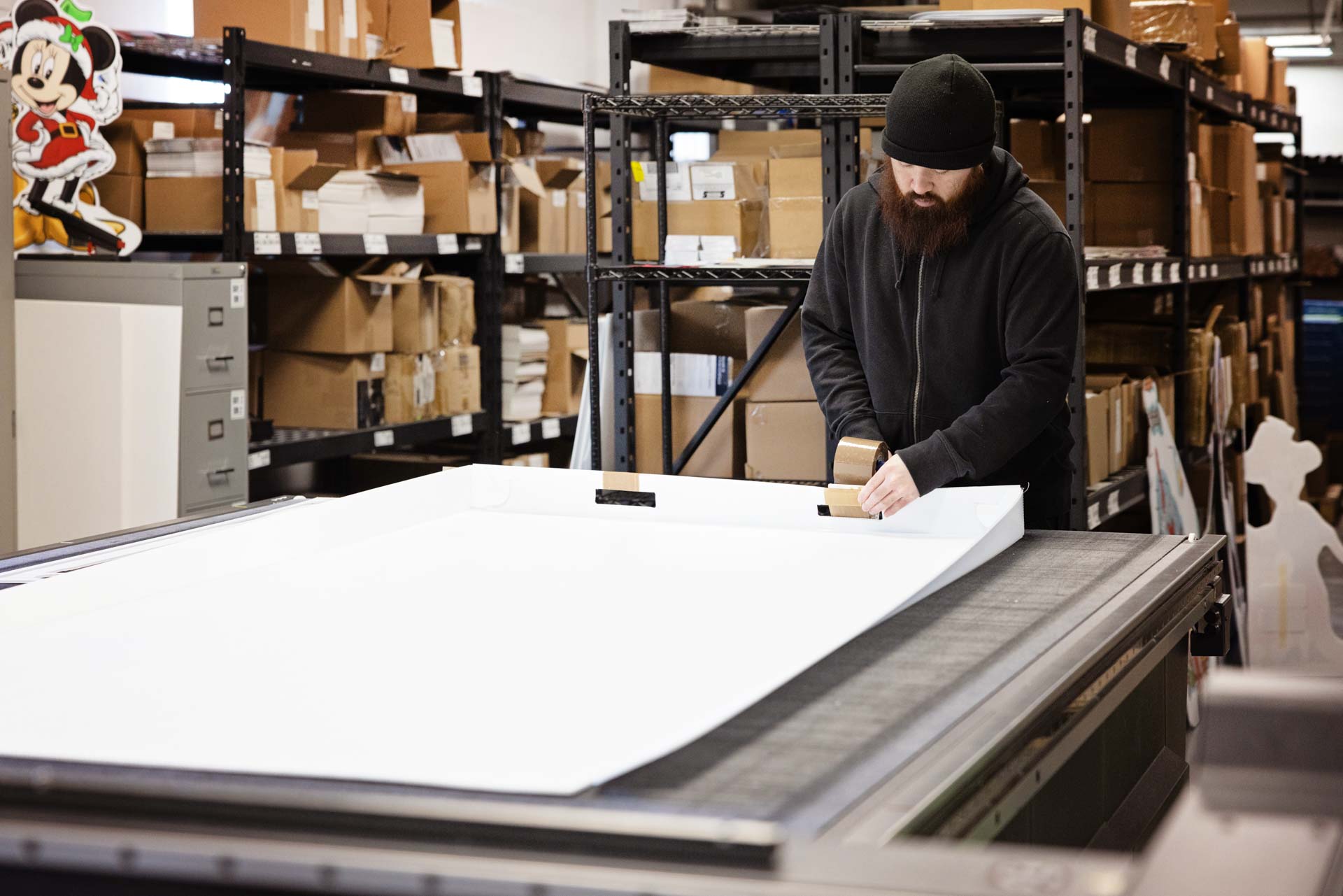 C17 Media team member finishing large format panels on the flatbed table at the Richmond Hill production facility