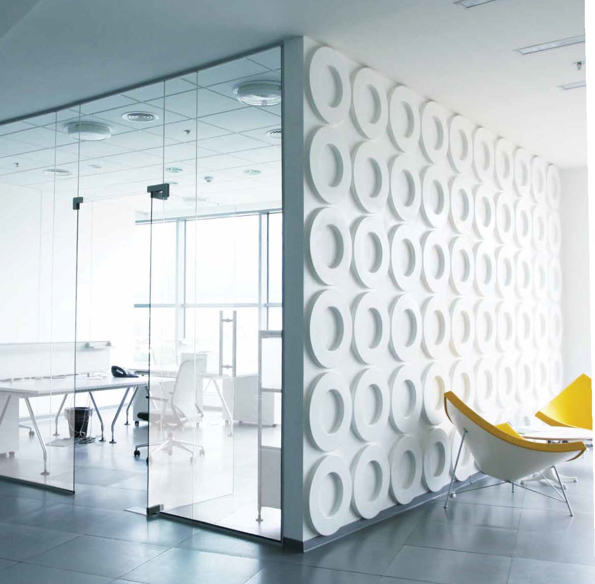 Clear glass office partition showing the fishbowl effect, with desks and meeting space fully visible from outside the room