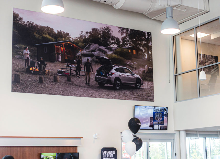 C17 Media installers fitting a large seamless fabric display wall inside a dealership showroom, the kind of premium interior finish work delivered outside business hours